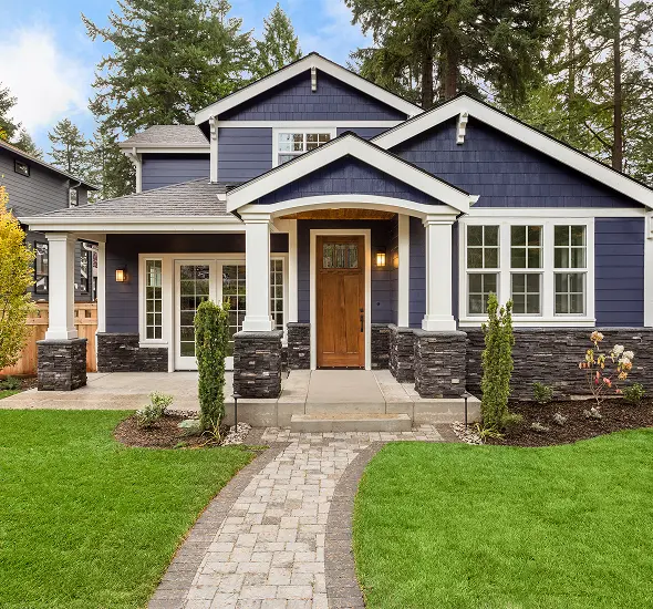 Charming blue house with stone accents and a welcoming front porch.